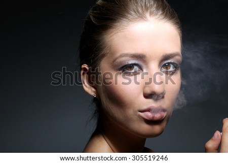 Portrait of a girl in tobacco smoke, in dark studio