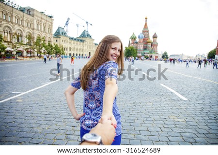 Follow me. Young happy girl pulls the guys hand on the Red Square in Moscow, Russia