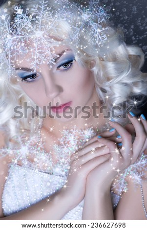 Portrait of snow queen.Winter Beauty Woman. Christmas Girl Makeup. Holiday Make-up. Snow Queen High Fashion Portrait over Blue Snow Background.