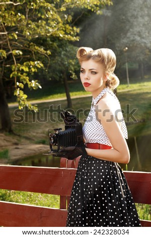 Retro girl holding a vintage camera.Beautiful woman with retro camera in the jungle.