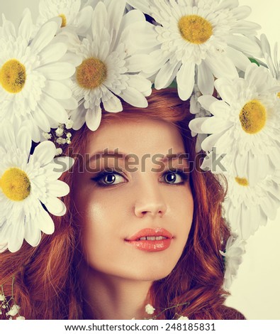 Redhead beautiful girl with a wreath of daisies on her head.Large daisies on long curly hair.instagram filter