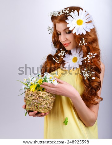 red-haired girl with daisies in her hair holding a bouquet of daisies.woman looking at flowers in a basket