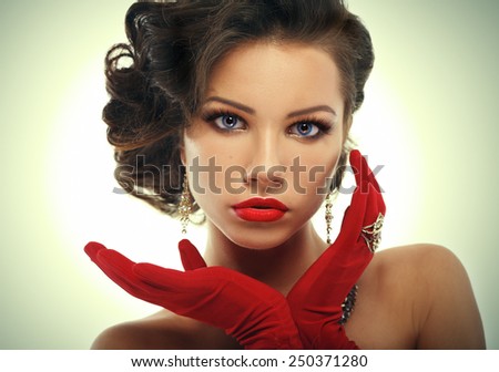 Glamour girl in red gloves holding hands near face. Vintage Style Mysterious Woman Wearing Red Glamour Gloves.