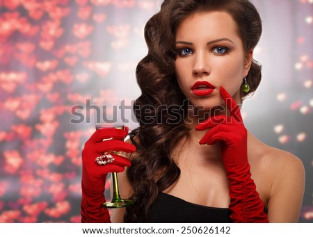 Glamour girl in red gloves holding a glass of champagne. drinking champagne. Beauty woman with perfect fashion makeup.congratulations on Valentine\'s Day