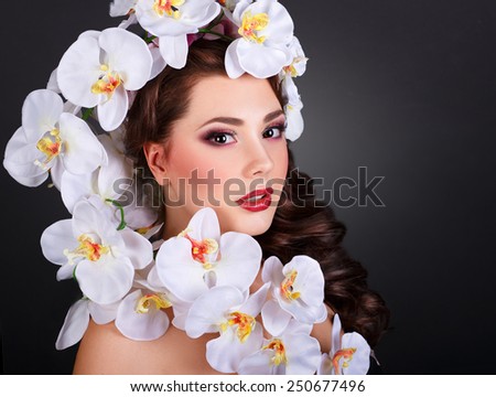 Fashion Beauty Model Girl with Orchid Flowers Hair. Bouquet of Beautiful Flowers on lady\'s head.Fashion Art