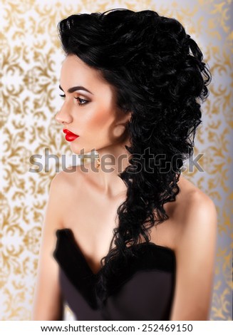 beauty portrait.Profile of beautiful girl with gorgeous hair and evening make-up.on a gold background