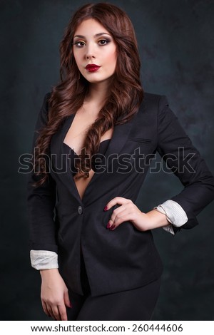 sexy business woman in a dark business suit. Beautiful sexy secretary rolls up his sleeves