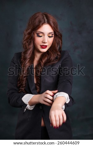 sexy business woman in a dark business suit. Beautiful sexy secretary rolls up his sleeves