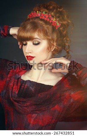 sexy beautiful redhead girl with long curly hair and a red dress.hair ornament.red lips. long thick bangs