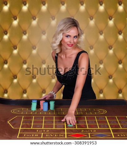 Girl playing in casino.Woman stakes piles of chips playing roulette at the casino club
