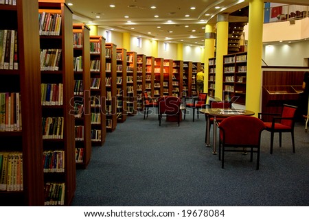 A view of rows of bookshelves and a study area inside a modern library.