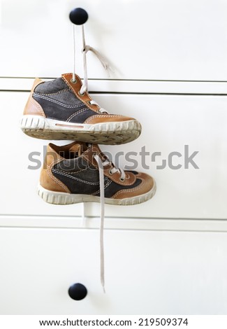 baby boy shoes hangs on a dresser