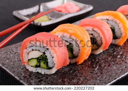 Sushi roll : Row of Salmon & tuna sushi roll with chopsticks on black plate