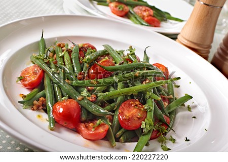 Green beans and tomato salad on white plate