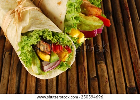 Wrap sandwich : Chicken avocado wrap sandwiches, wooden mat.
