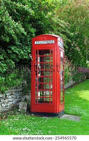 Red telephone box, English village countryside. Vertical.