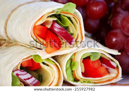 Wrap sandwich : Closeup of ham and cheese wrap sandwiches with grapes