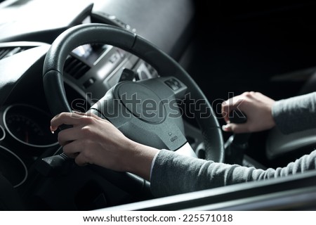 Woman driving a car, hands on steering wheel close-up.