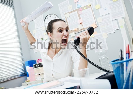 Angry stressed businesswoman on the phone screaming out loud.