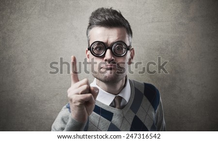 Angry funny guy with glasses reproaching somebody and pointing