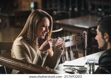 Romantic young couple dating and flirting at the bar, staring at each other's eyes