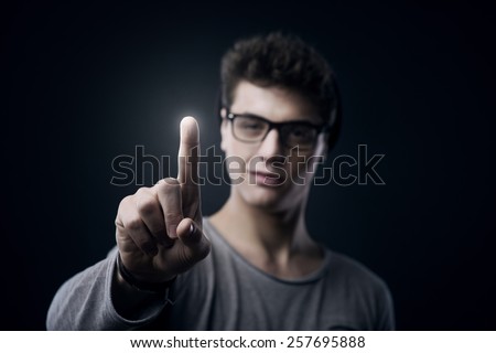 Smiling teenager using touch screen interface with index finger