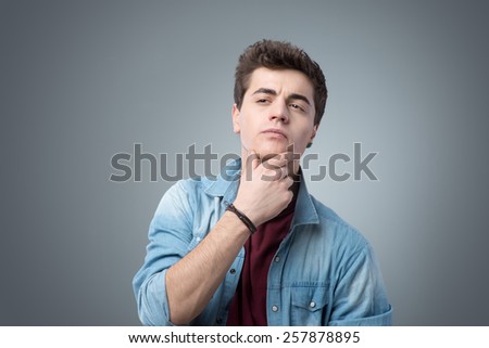 Male teenager checking his face skin looking for blemishes