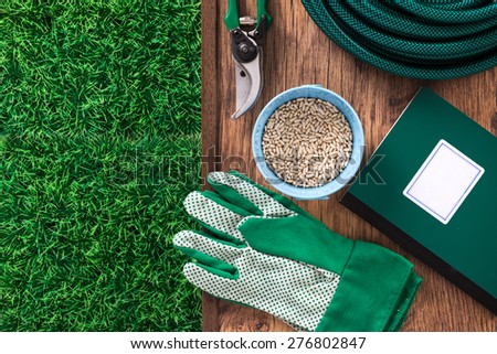 Farming and home gardening tools with green grass and farming manual book guide, top view