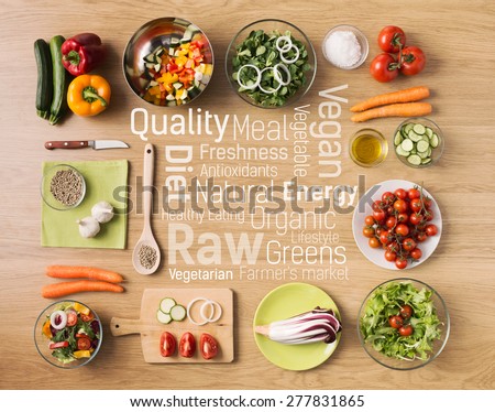 Creative vegetarian cooking at home with fresh healthy vegetables chopped, kitchen utensils and healthy eating text concepts at center