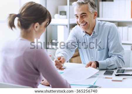 Young woman having a business meeting and signing a contract, recruitment and agreement concept