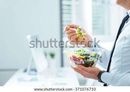 Businessman having a vegetables salad for lunch, healthy eating and lifestyle concept, unrecognizable person