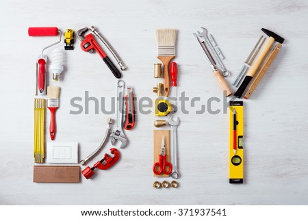 DIY word composed of work and construction tools on a wooden surface top view, hobby and craft concept