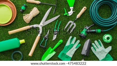 Gardening tools and utensils on a lush green meadow, top view, garden manteinance, landscaping and hobby concept
