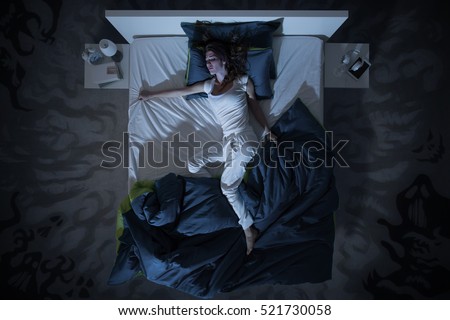 Nervous woman in bed have a nightmare at midnight, she is  restless, top view