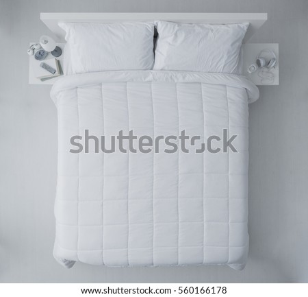 Elegant bedroom with white duvet and sheets, top view