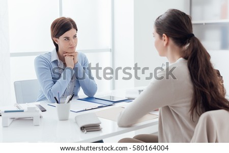 Business meeting in the office and job interview: a female executive is meeting the candidate and talking