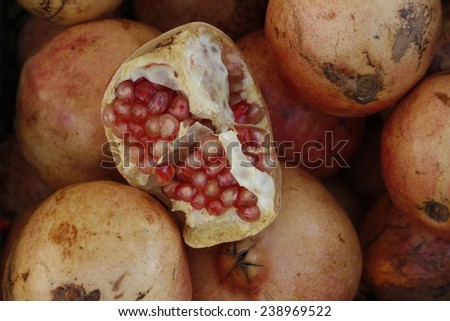 Ripe pomegranates background. Half pomegranate and raw pomegranates. Pomegranates in market.