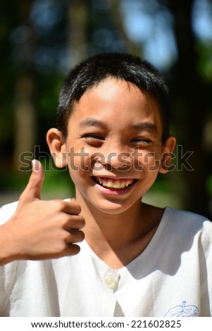 smiling face of Asian boy with thump up