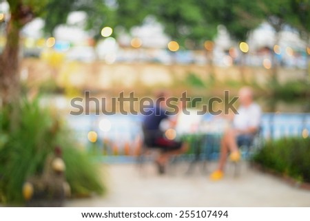 blur two men sitting outdoor of cafe background