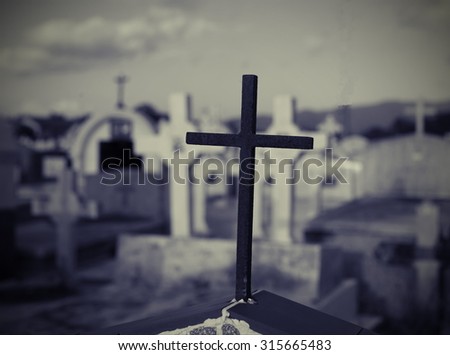 cross in graveyard in black and white