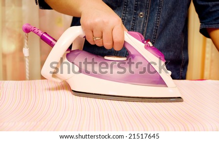 ironing clothes with steam iron at board