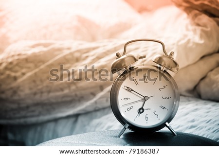 clock and bed showing wake time in bedroom