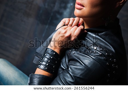 stylish girl in black leather jacket, black leather bracelet on the hand