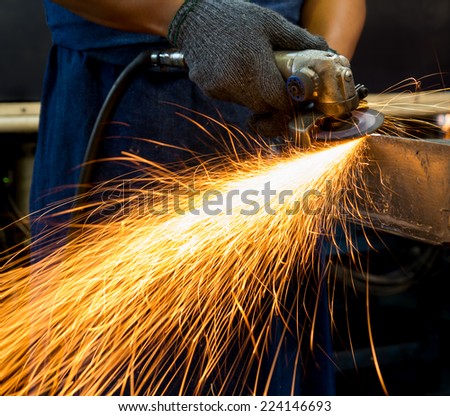 factory worker using electric grinder