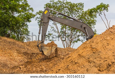 industrial backhoe, bulldozer moving earth and sand in sandpit or quarry