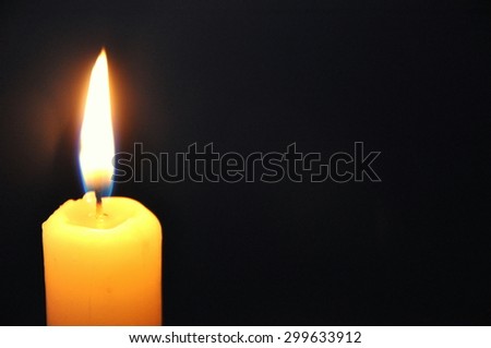 White candle burning in the dark