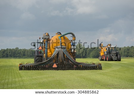 Agriculture, injecting of liquid manure with two tractors and yellow vulture spreader trailers
