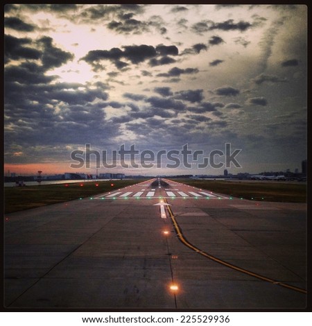 The runway at night, beneath the soft puffy clouds.