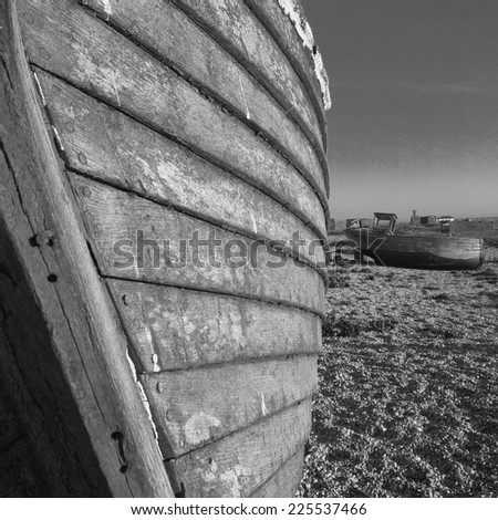Two beached wooden boats in need of repair.