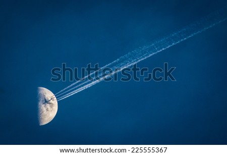 A jet plane flying with the moon in the background.